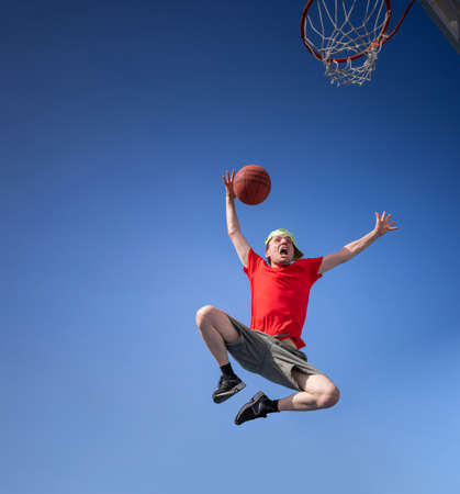 Crazy boy having fun laughing and playing basketballの写真素材