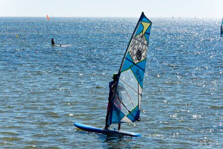 Windsurfing on Baltic Sea. Unidentifiable Windsurfer Surfing The Wind On Waves, Recreational Water Sports, Selective focusの写真素材