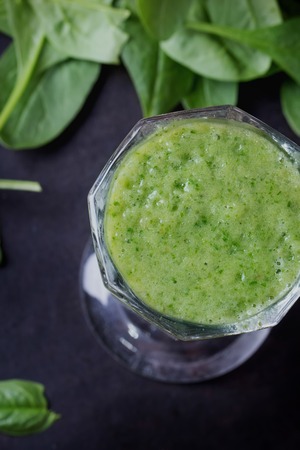 Glass of refreshing green smothie served with green apple, baby spinach leaves, soya sprouts and an egg yolkの写真素材