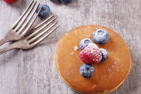 Home-made breakfast or brunch: american style pancakes served with berries and sugar powder, top...