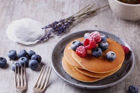 Home-made breakfast or brunch: american style pancakes served with berries and sugar powder on...