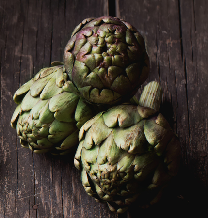 Ripe Organic Artichokes on the rustic wooden boardの写真素材