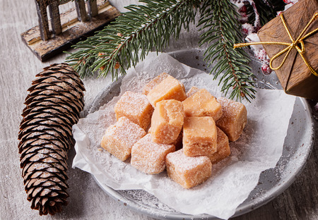 Creamy Caramel fudge on grey background with furt tree and christmas decorationの写真素材