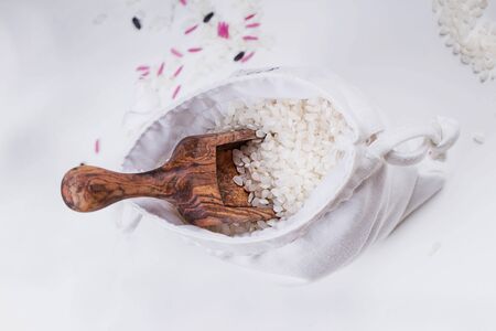 Set of unusual rice in the bag with a scoop over a white table. Isolated. Top Viewの写真素材