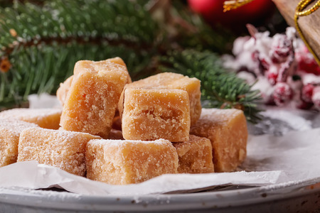 Creamy Caramel fudge on grey background with furt tree and christmas decorationの写真素材