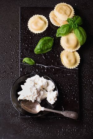 Homemade ravioli pasta with fresh basil and cheese over the stone marble board. Top Viewの写真素材