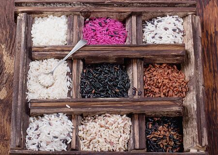 Set of unusual rice in vintage wooden box over a rustic wooden background. Top Viewの写真素材