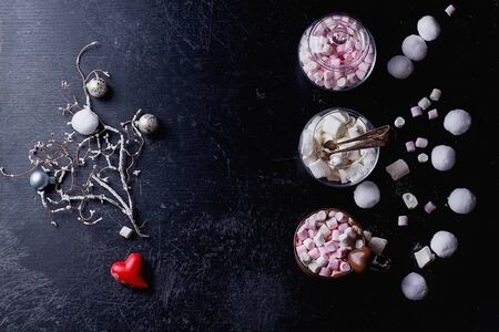 Hot Cacao drink served with marhsmallows with vatious christmas and st valentine's decorations over...