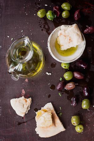Black and green olives served with Olive Oil on rustic wooden board. Top Viewの写真素材
