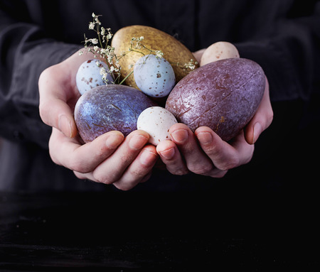 Male hands holding Chocolate Easter Eggs. Rustic Easter Concept. Copy Spaceの写真素材