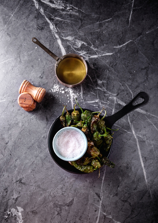Traditional Spanish Tapas Pimientos de Padron - fried small peppers serves with sea salt and olive oil. Top View. Copy Spaceの写真素材