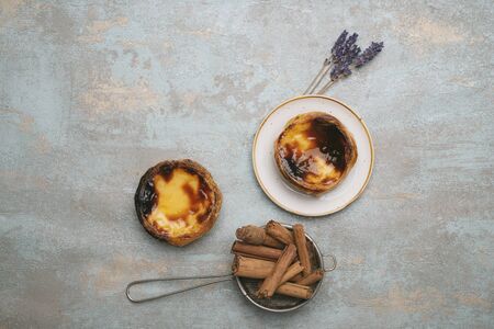 Pastel de nata. Traditional Portuguese dessert, egg tart on the plate and over rustic background...