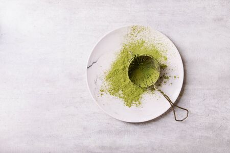 Vintage metal strainer with Matcha tea on ceramic plate. Top View. Copy Spaceの写真素材