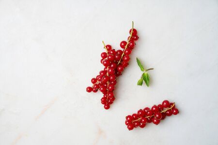 Bunch of fresh red currant berries over marble background. Top viewの写真素材