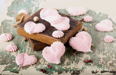 Heart shaped meringues on wooden boards and around.の写真素材