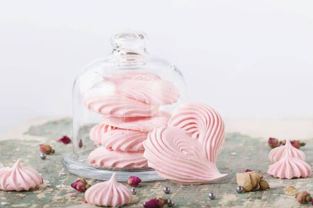 Heart shaped meringues in glass cookie jar and aroundの写真素材