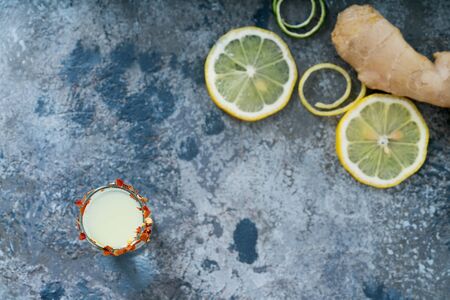 Ginger lemon shot, lemon slices and ginger. Immune boosting health defending drink. Rustic background. Top view. Selective focusの写真素材