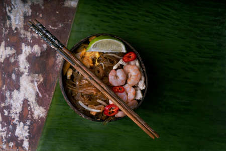 Traditional Thai Noodles. Fried Noodles Pad Thai with shrimp and chiÑken n coconut bowls with...