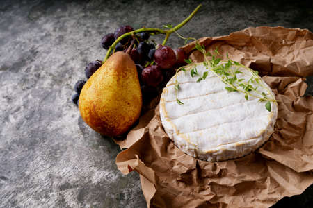 French cheese Camembert covered with honey, dried lavender stems on the paper  and freshly baked baguette over dark rustic background. Top view. Copy spaceの写真素材