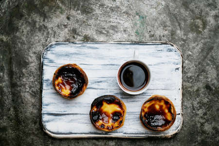 Pastel de Nata. Traditional Portuguese dessert, egg tart on the board with cup of fragrant coffee...