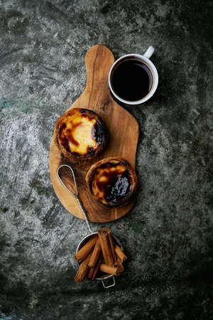Pastel de Nata. Traditional Portuguese dessert, egg tart on the board with cup of coffee and...