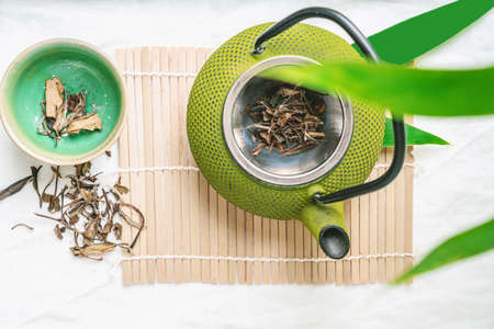 Chinenese dry tea leaves with teapot decorated with maple leaves. Relaxation Concept. Flat lay. Top Viewの写真素材