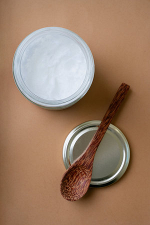 Selective Focus on plain white yogurt in glass jar with coconut spoons. Top View. Flat Lay....
