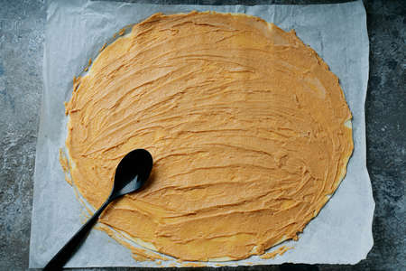 Cooking process of apple swirls. Dough with spread peanut butter filling and spoon. Top View. Flat layの写真素材