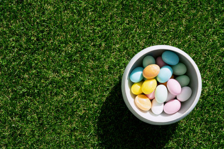 Chocolate Easter eggs glazed with pastel coloring in a bowl over green grass background. Happy...