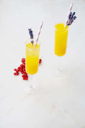 Homemade Mimosa Cocktails served with straw and dried lavender flowers in a glass. Orange juice with Champaigne. High angle view. Selective focus.の写真素材