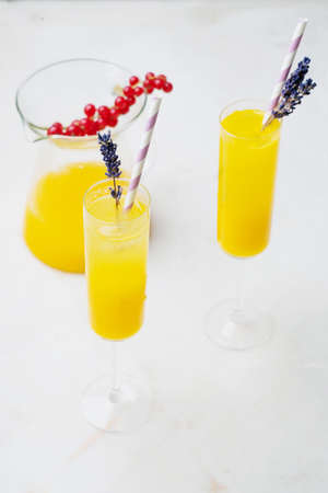 Homemade Mimosa Cocktails served with straw and dried lavender flowers in a glass. Orange juice with Champaigne. High angle view. Selective focus.の写真素材
