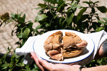 Man holding traditional portuguese Sandwich bifana over street background. Street food conceptの写真素材