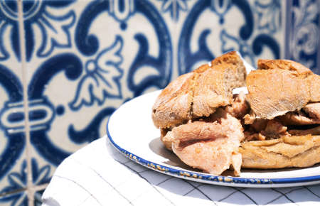 Traditional portuguese Sandwich bifana over traditional portuguese background tiles azulejoの写真素材