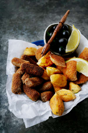 Traditional Portuguese snacks shrimp rissoles, beef croquettes and cod fish pasties served with lemon and olives. Rissois de camarÃ£o, pasteis de bacalhau, croquettes de carne. Selective focusの写真素材
