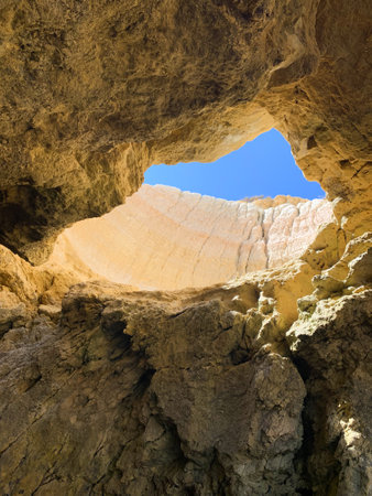 Stunning view of Algarve, Portugal, showcasing golden beaches, rocky cliffs, sea caves, and turquoise water. Includes scenic beachside sunbeds, coastal rock formations, and natural cave openings.の写真素材