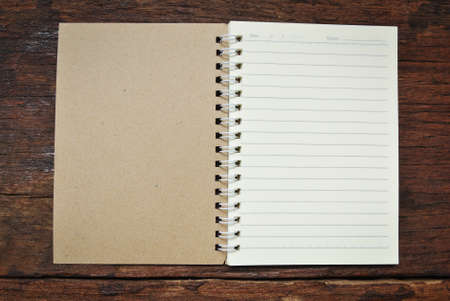 Brown notebook on a wood backgroundの写真素材
