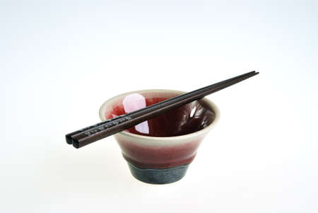 Green red ceramic bowl with wooden chopsticksの写真素材