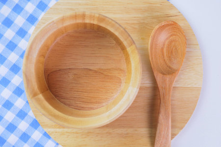 Wooden plate, tablecloth, spoon, fork on table backgroundの写真素材