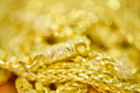 Blured defocused Gold necklaces , bracelets  and bokeh for gold backgroundの写真素材