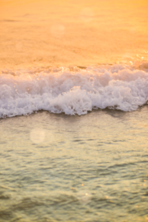 surf sea blured wave  at golden light sunset beach background defocused summerの写真素材
