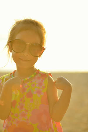 Defocused and blurred image Child kid posing and fun on the beach with golden light at sunset summerの写真素材