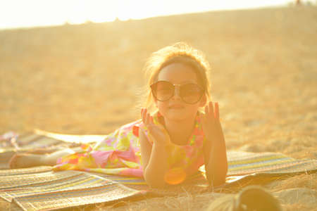 Defocused and blurred image Child kid posing and fun on the beach with golden light at sunset summerの写真素材
