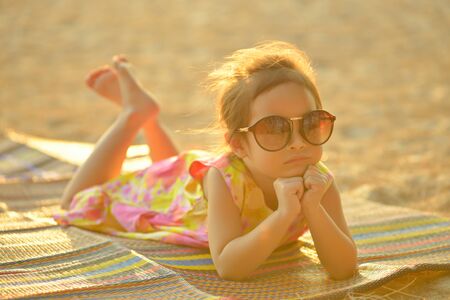 Defocused and blurred image Child kid posing and fun on the beach with golden light at sunset summerの写真素材