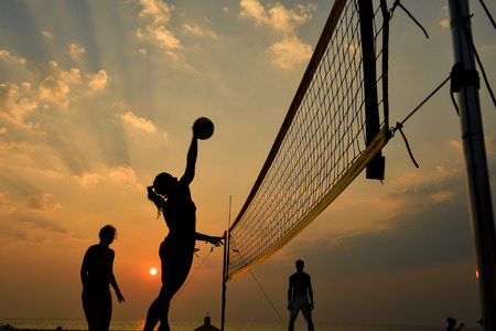 Beach volleyball silhouette at sunset , motion blurred