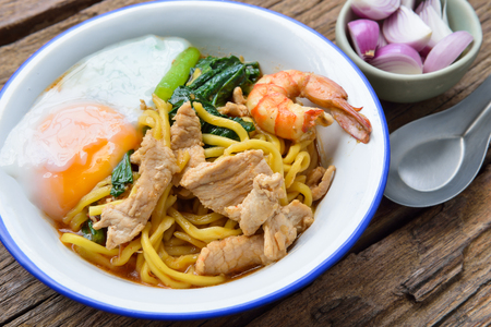 Stir fried yellow noodles with seafood , pork and soft-boiled egg  , local folk south thai styleの写真素材