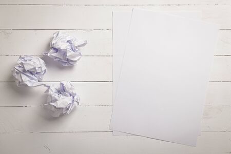 White paper and Crumpled paper balls on white color wood plank background with space for textの写真素材
