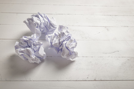 White paper and Crumpled paper balls on white color wood plank background with space for textの写真素材