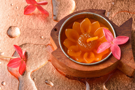 Red flowers candle and droplets on the surface of copper. Feel freshness spa concept,  studio shot spa and aromatherapy conceptの写真素材