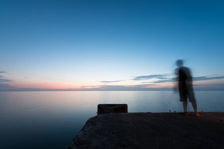 Abstract Blur silhouette of man fishing rod sunset backgroundの写真素材