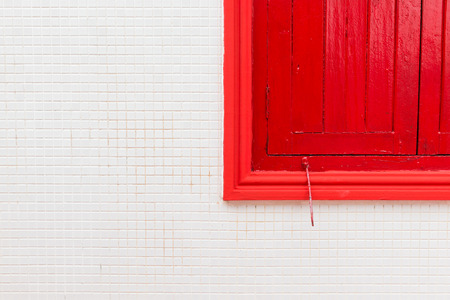 Red window on old white wallの写真素材
